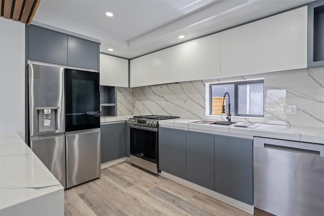 312 N 3rd Ave, Marshalltown, IA 50158 - kitchen featuring recessed lighting, stainless steel appliances, modern cabinets, light wood-style floors, and decorative backsplash