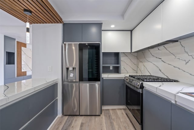 312 N 3rd Ave, Marshalltown, IA 50158 - kitchen with light stone countertops, gray cabinetry, stainless steel appliances, and light wood-style floors