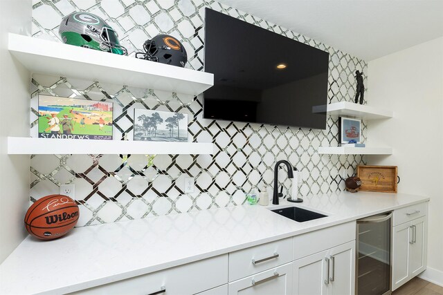 5094 Grand Ridge Dr, West Des Moines, IA 50265 - indoor wet bar featuring wine cooler and tasteful backsplash