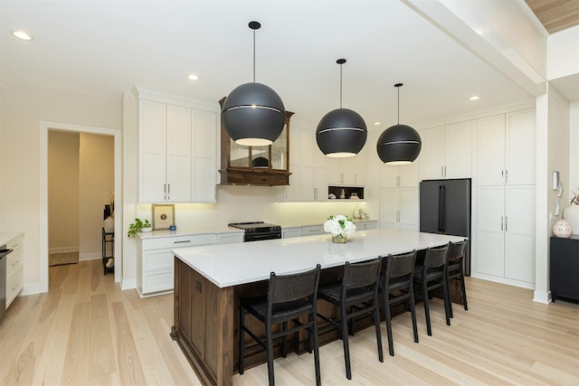 5094 Grand Ridge Dr, West Des Moines, IA 50265 - kitchen with electric range, light wood finished floors, white cabinets, light countertops, and a spacious island