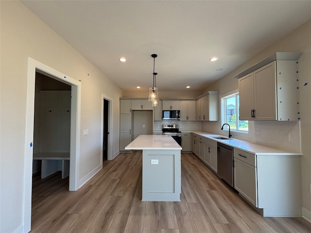 1258 S 92nd St, West Des Moines, IA 50266 - kitchen with stainless steel appliances, tasteful backsplash, light wood-type flooring, a center island, and light countertops