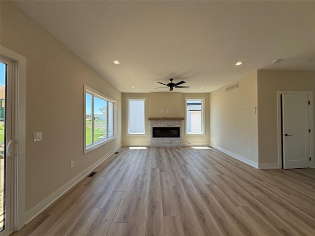 1258 S 92nd St, West Des Moines, IA 50266 - unfurnished living room with ceiling fan, light wood-type flooring, healthy amount of natural light, recessed lighting, and a fireplace