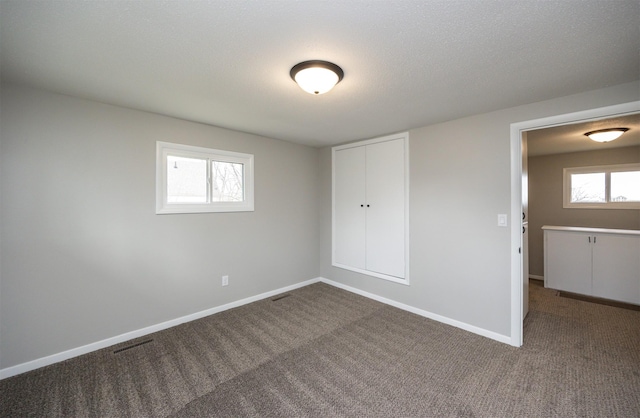unfurnished bedroom with carpet floors, visible vents, and baseboards