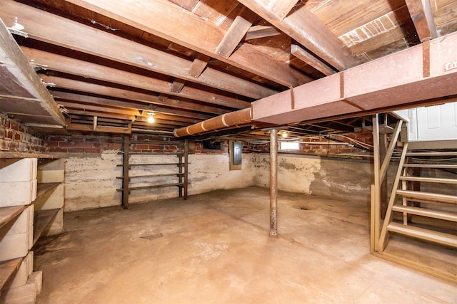 unfinished basement with electric panel and stairs