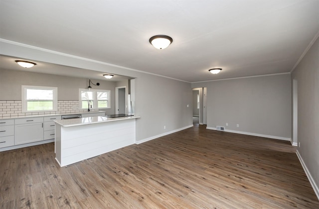 kitchen featuring white cabinets, backsplash, light countertops, visible vents, and open floor plan