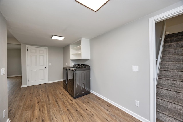 kitchen featuring washing machine and dryer, baseboards, white cabinetry, wood finished floors, and open shelves