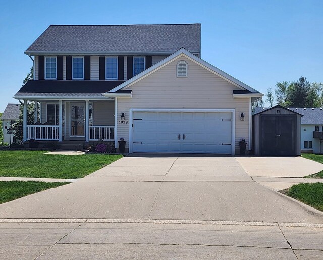 3029 Hart Ave, Des Moines, IA 50320 - traditional-style house featuring a storage unit, covered porch, a front lawn, an attached garage, and driveway