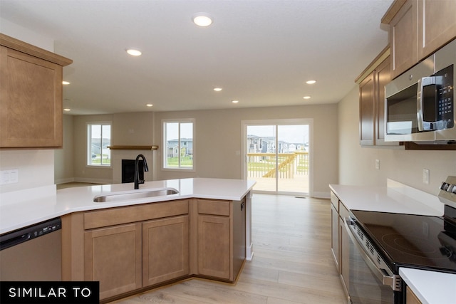 4312 NE 8th St, Ankeny, IA 50021 - kitchen featuring light wood finished floors, a peninsula, a sink, recessed lighting, and appliances with stainless steel finishes