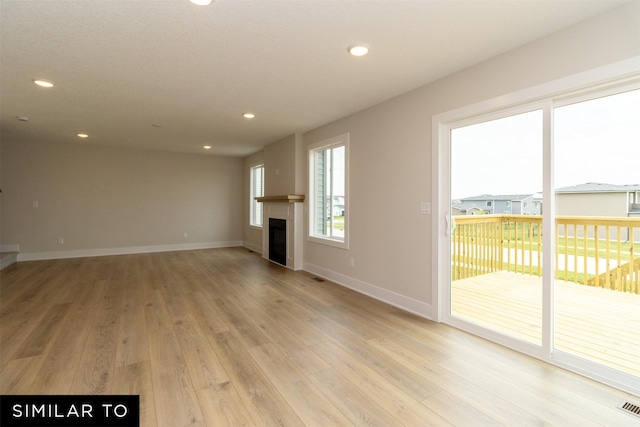 4312 NE 8th St, Ankeny, IA 50021 - unfurnished living room with recessed lighting, visible vents, light wood-type flooring, baseboards, and a glass covered fireplace