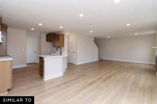 4312 NE 8th St, Ankeny, IA 50021 - kitchen with recessed lighting, light countertops, a sink, baseboards, and light wood-style flooring