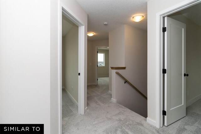 4312 NE 8th St, Ankeny, IA 50021 - hallway with a textured ceiling, carpet flooring, baseboards, and an upstairs landing