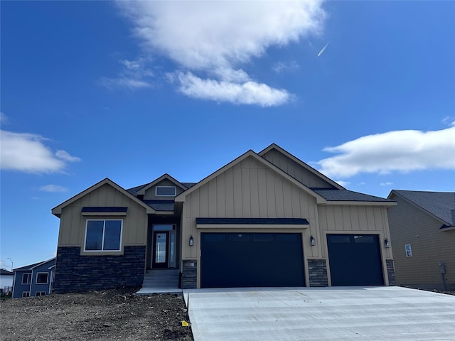 craftsman house featuring board and batten siding, concrete driveway, stone siding, and a garage