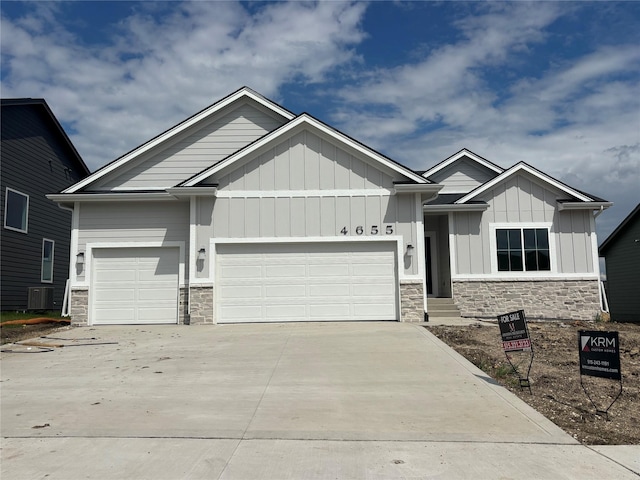 4655 178th St, Urbandale, IA 50263 - craftsman-style house featuring stone siding, board and batten siding, a garage, and driveway