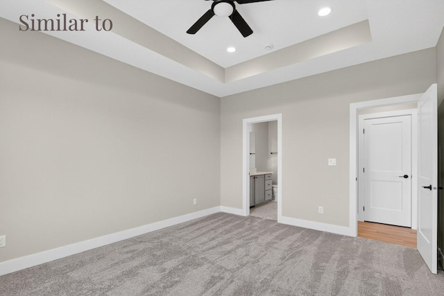 2934 Lake Hill Dr, Des Moines, IA 50320 - unfurnished bedroom featuring light colored carpet, a tray ceiling, recessed lighting, ensuite bath, and a ceiling fan
