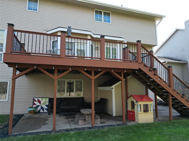 back of property featuring a wooden deck, outdoor lounge area, a patio, and stairs