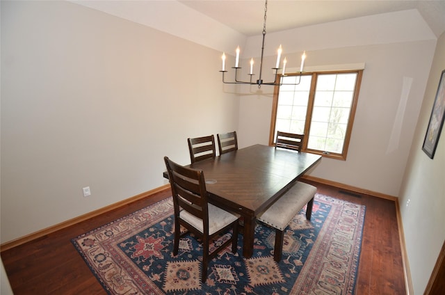 dining area featuring a chandelier, wood finished floors, and baseboards