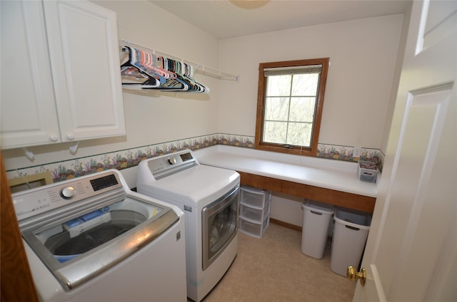 clothes washing area with washer and dryer and cabinet space