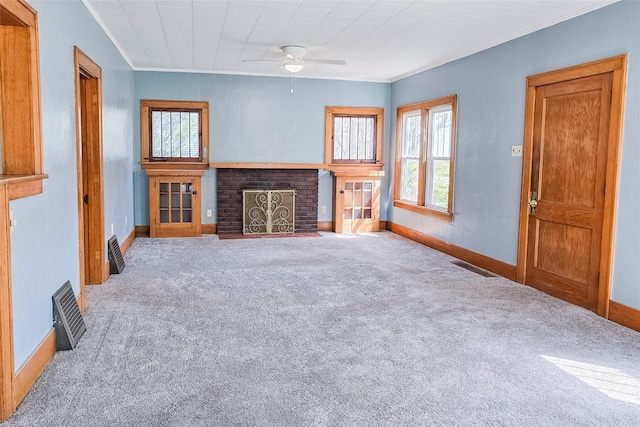 unfurnished living room featuring plenty of natural light, baseboards, carpet floors, and ceiling fan