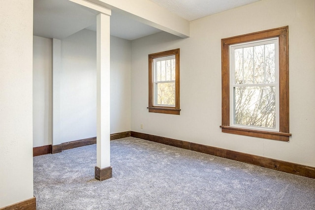 carpeted empty room featuring baseboards