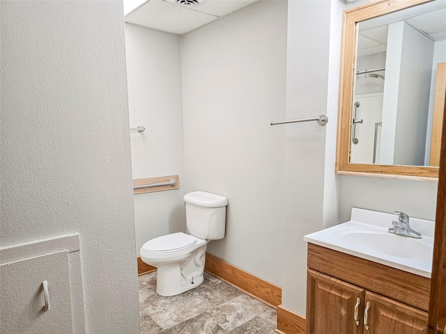 bathroom featuring baseboards, toilet, and vanity