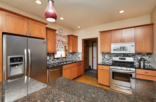 kitchen featuring backsplash, recessed lighting, stainless steel appliances, and a sink