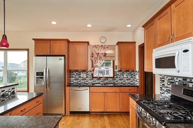 kitchen featuring a sink, brown cabinets, appliances with stainless steel finishes, and tasteful backsplash