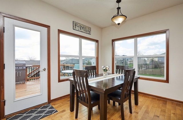 dining space featuring light wood-style flooring, a wealth of natural light, and baseboards