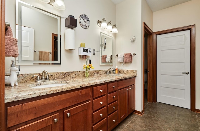 full bathroom with tile patterned flooring, baseboards, a sink, and double vanity