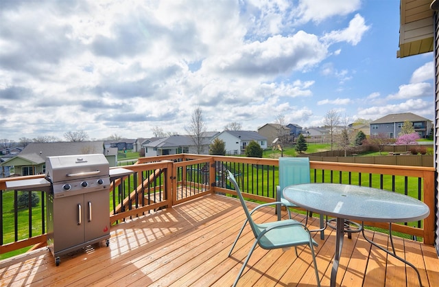 wooden deck with grilling area, fence, a residential view, and a lawn