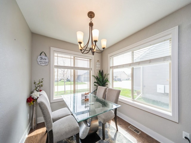1110 NE 15th Ln, Ankeny, IA 50021 - dining room with wood finished floors, visible vents, baseboards, and a notable chandelier