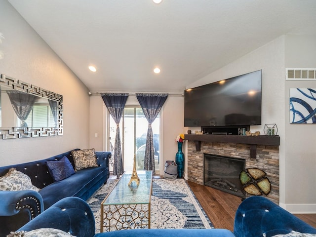 1110 NE 15th Ln, Ankeny, IA 50021 - living area featuring vaulted ceiling, visible vents, a stone fireplace, and wood finished floors