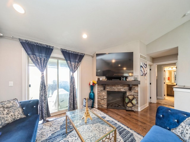 1110 NE 15th Ln, Ankeny, IA 50021 - living room with wood finished floors, a fireplace, baseboards, lofted ceiling, and visible vents