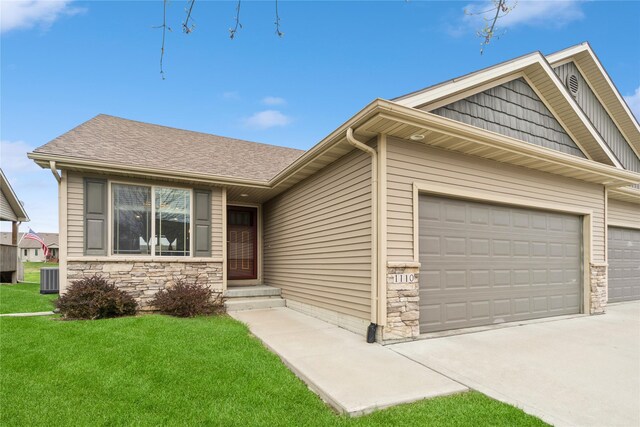 1110 NE 15th Ln, Ankeny, IA 50021 - ranch-style house with a front lawn, driveway, stone siding, and a garage