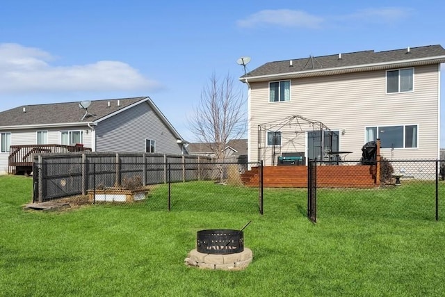 717 37th St SW, Bondurant, IA 50035 - rear view of house featuring a fire pit, fence, a deck, and a lawn