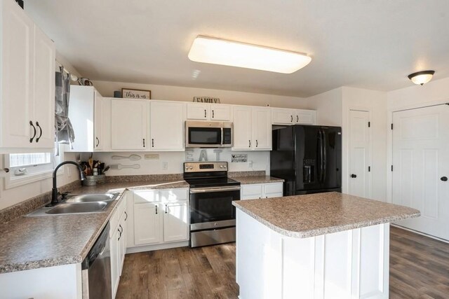 717 37th St SW, Bondurant, IA 50035 - kitchen featuring a sink, dark wood-style flooring, white cabinetry, a kitchen island, and appliances with stainless steel finishes