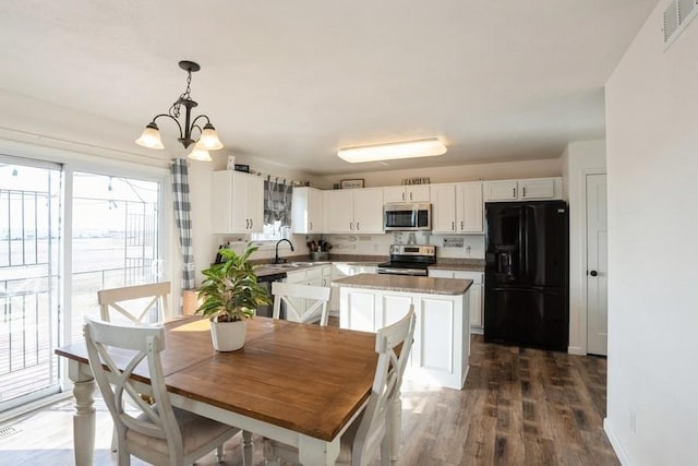 717 37th St SW, Bondurant, IA 50035 - dining area with an inviting chandelier, dark wood-type flooring, and visible vents