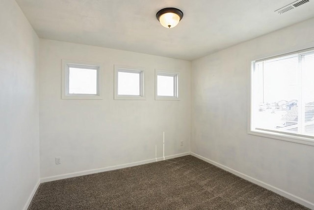 717 37th St SW, Bondurant, IA 50035 - spare room with dark carpet, baseboards, and visible vents