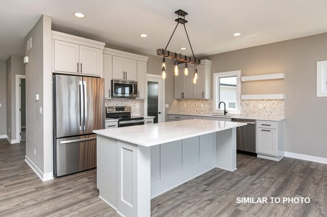 530 Walnut Dr, Huxley, IA 50124 - kitchen featuring stainless steel appliances, a kitchen island, decorative backsplash, light countertops, and recessed lighting