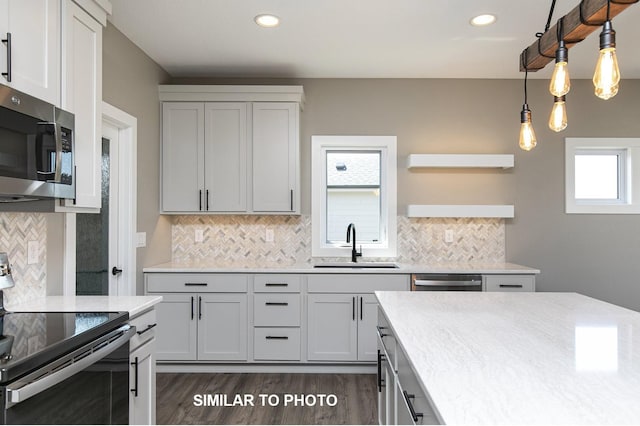 kitchen featuring recessed lighting, dark wood finished floors, a sink, tasteful backsplash, and appliances with stainless steel finishes