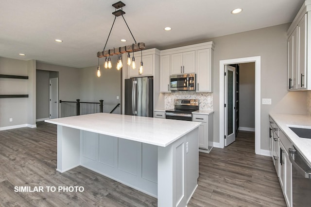 530 Walnut Dr, Huxley, IA 50124 - kitchen with stainless steel appliances, dark wood finished floors, decorative backsplash, a center island, and recessed lighting