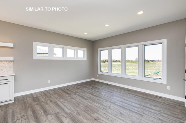 530 Walnut Dr, Huxley, IA 50124 - unfurnished living room with wood finished floors and recessed lighting