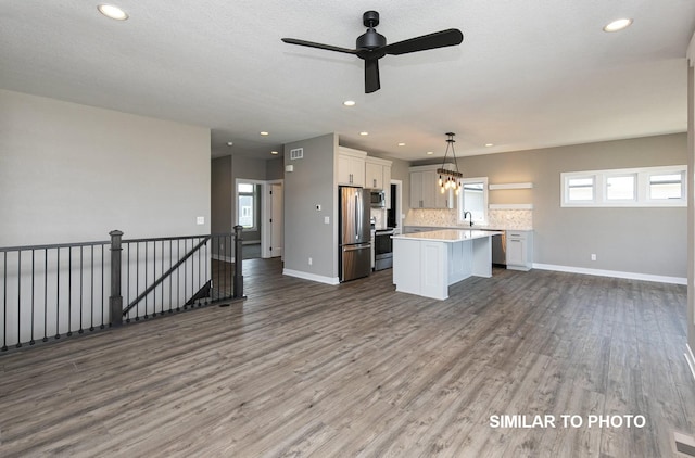 530 Walnut Dr, Huxley, IA 50124 - kitchen with open floor plan, appliances with stainless steel finishes, light countertops, a kitchen island, and recessed lighting