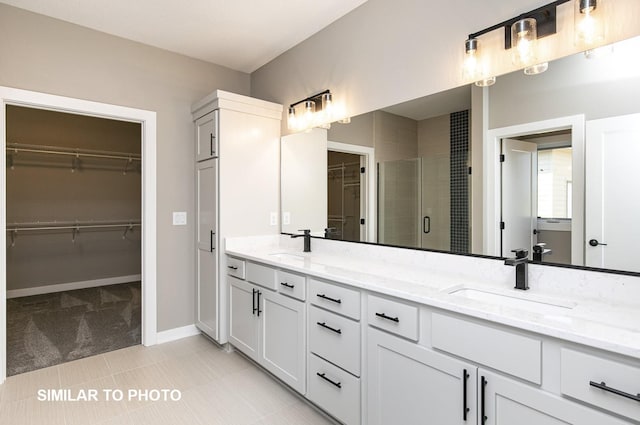 530 Walnut Dr, Huxley, IA 50124 - bathroom with double vanity, a shower stall, a spacious closet, and tile patterned floors