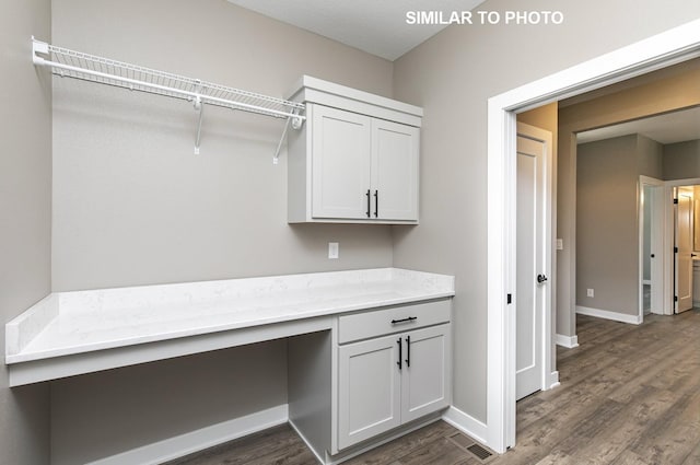laundry area with baseboards, visible vents, and dark wood-style floors