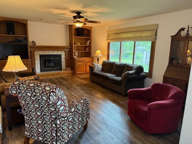 4508 49th St, Des Moines, IA 50310 - living area with wood finished floors, a fireplace, and a ceiling fan