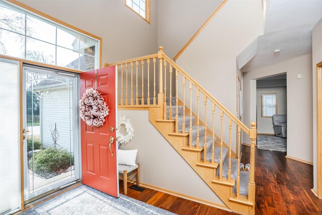 748 76th St, West Des Moines, IA 50266 - foyer entrance featuring baseboards, wood finished floors, a high ceiling, and stairway