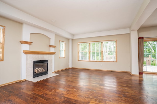 748 76th St, West Des Moines, IA 50266 - unfurnished living room with a tiled fireplace, wood finished floors, and baseboards