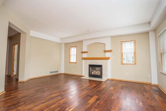 748 76th St, West Des Moines, IA 50266 - unfurnished living room featuring wood-type flooring, a tile fireplace, and healthy amount of natural light