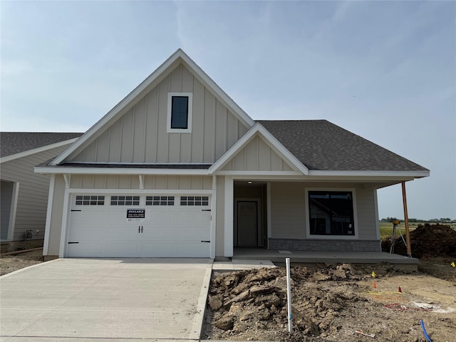 1528 Garland Ave, Norwalk, IA 50021 - view of front of home featuring board and batten siding, a porch, driveway, and roof with shingles