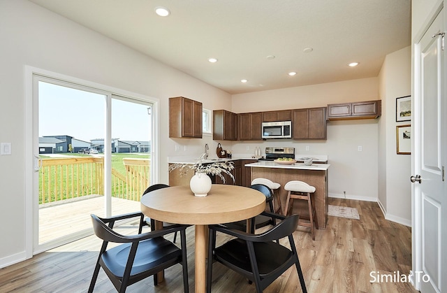 dining room featuring baseboards, light wood-style flooring, and recessed lighting